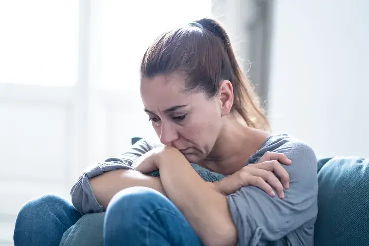 Mulher abatida sentada em um sofá